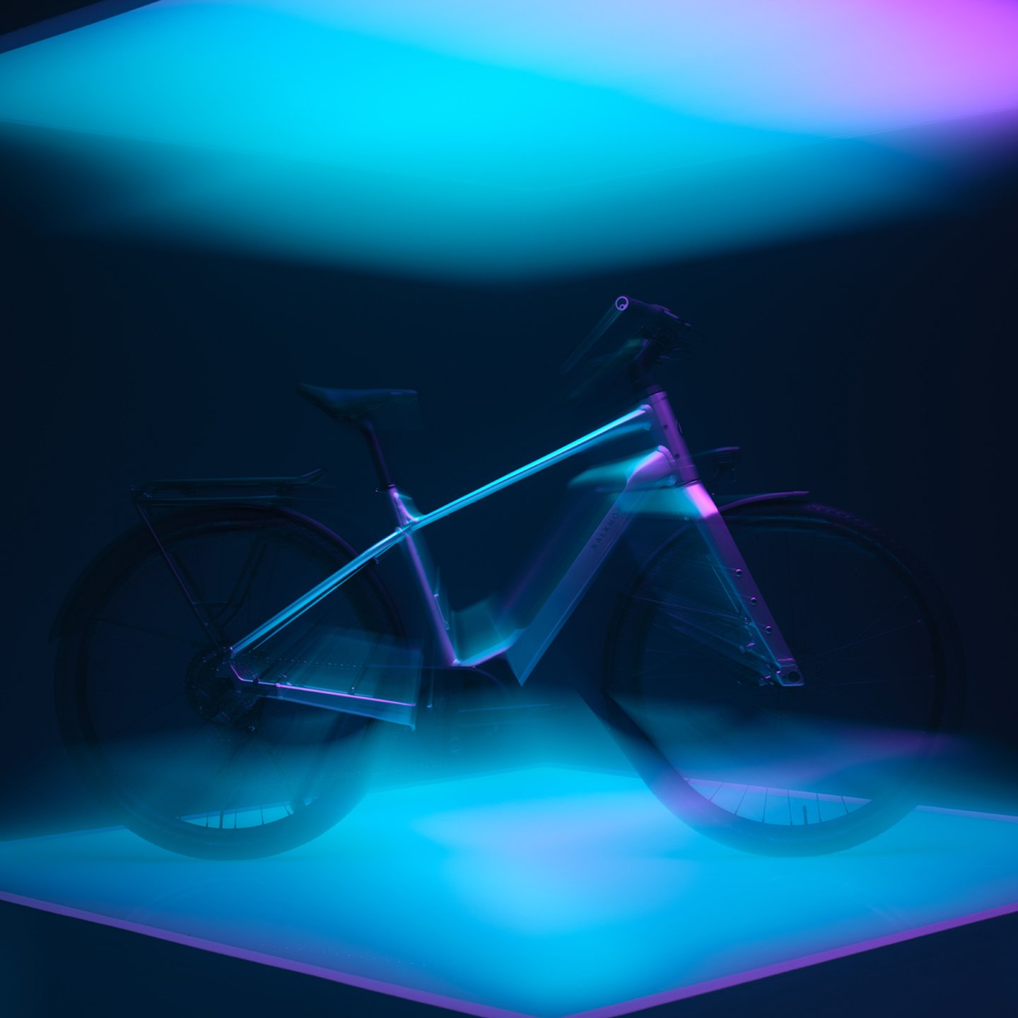 Ein Kalkhoff E-Bike, das von leuchtend blauen und violetten Lichtern beleuchtet wird.