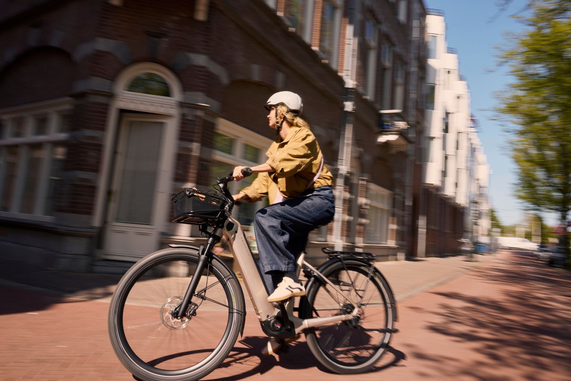 Frau fährt auf einem Kalkhoff E-Bike in der Stadt um die Kurve