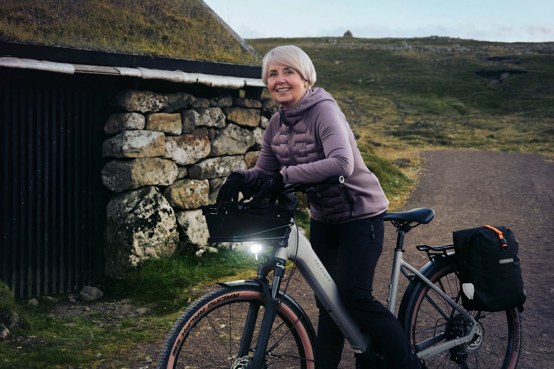 Frau steht mit ihrem Kalkhoff Rad in der Natur.