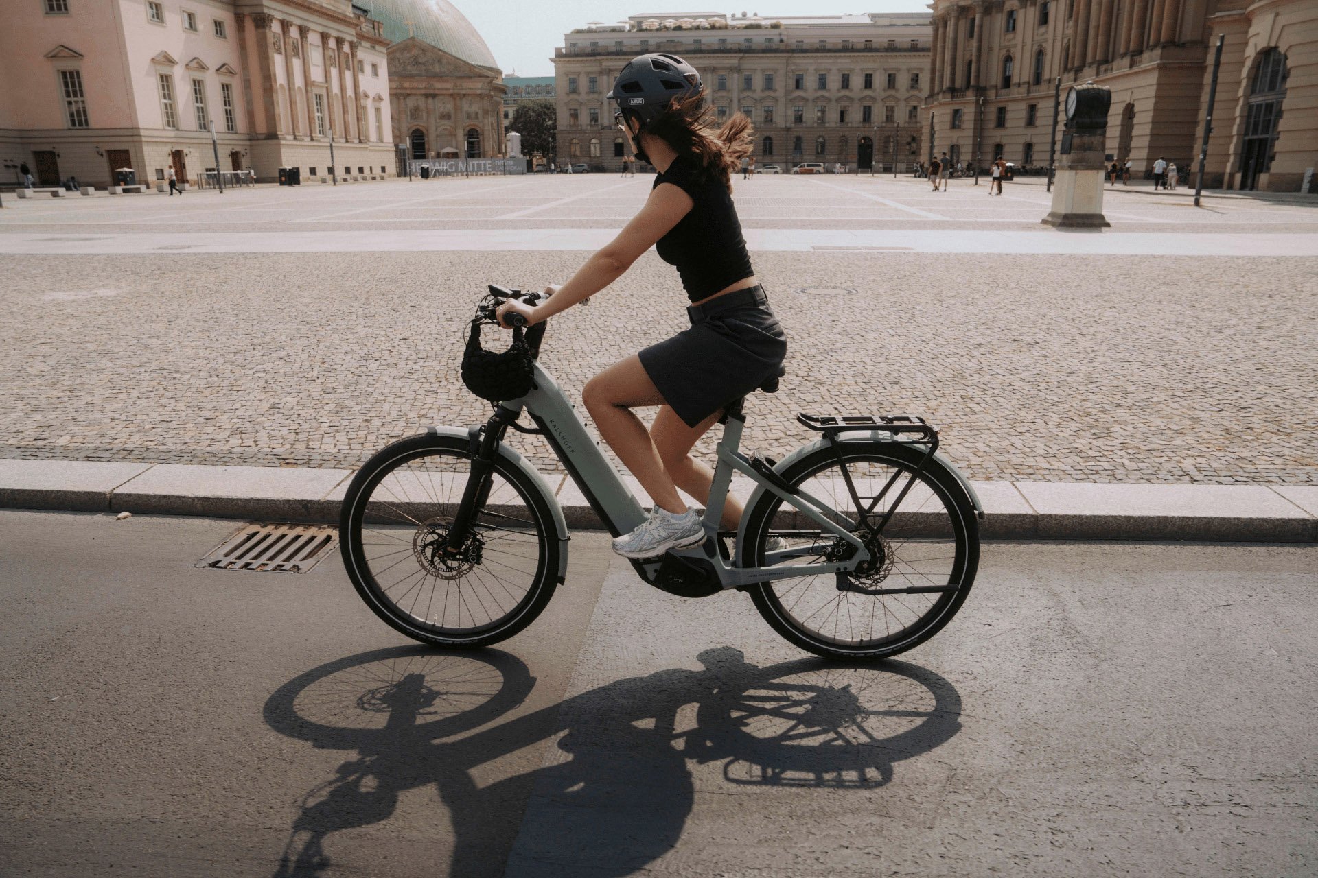 Frau fährt mit Kalkhoff E-Bike durch die Stadt