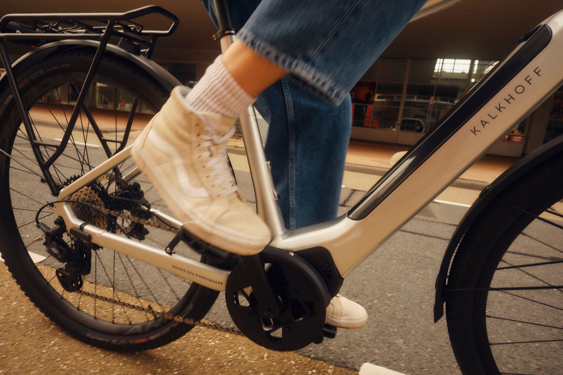 Nahaufnahme von den Beinen einer Frau, die gerade ein Kalkhoff E-Bike fährt.