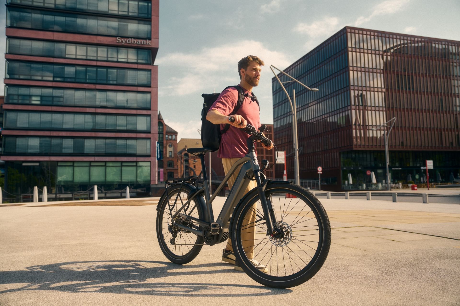 Mann schiebt sein Kalkhoff-Bike durch die Stadt