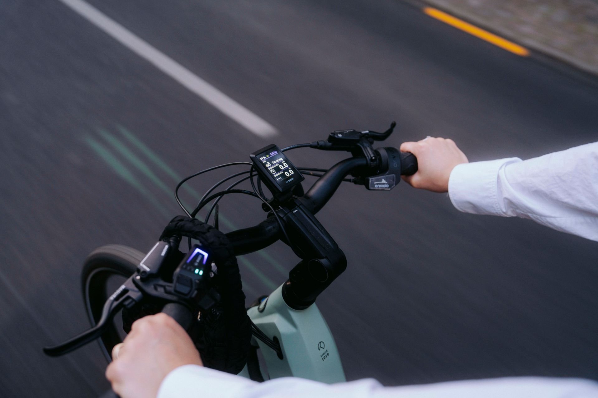 Nahaufnahme von dem Lenkrad, wo das Bosch Display zu sehen ist. Das Bild ist entstanden, während die Person mit dem Kalkoff E-Bike fährt.
