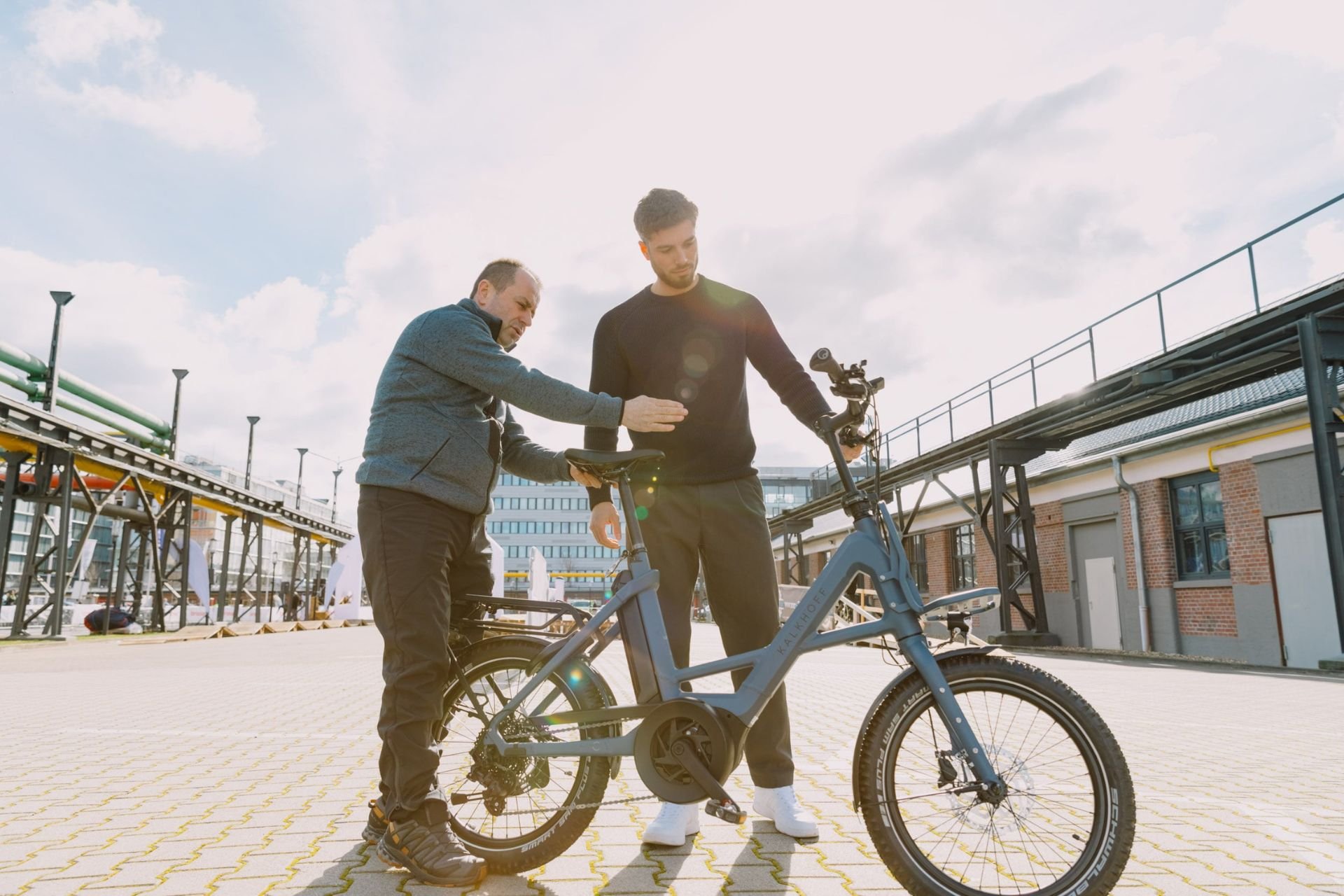 E-Bike kaufen: Der ultimative Guide Mann erklärt einem Kunden etwas an unserem Kalkhoff Compact Bike