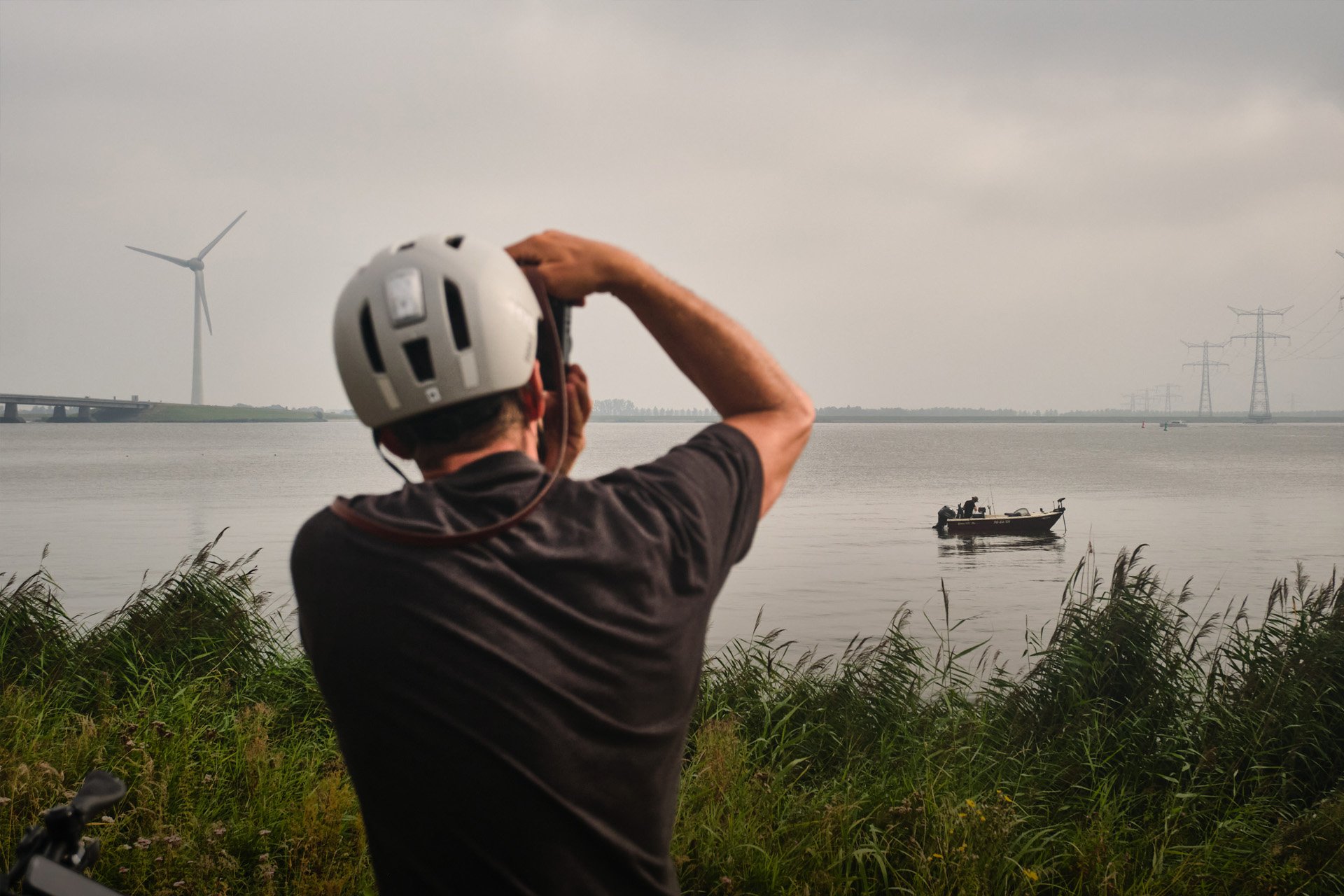 Fotografieren beim Radfahren? Mit den richtigen Tipps gelingen deine Schnappschüsse. (Foto: Kalkhoff/Roske) Mann mit Fahrradhelm fotografiert Meer