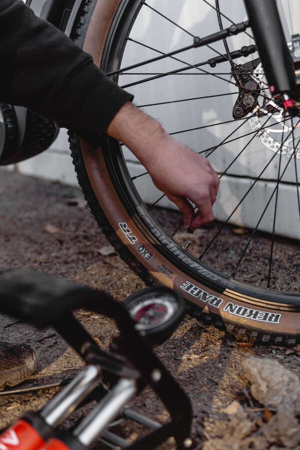 Mann prüft den Luftdruck seines E-Bike Reifens