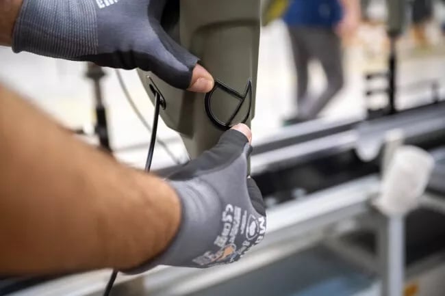 Hier wird gerade das Kalkhoff Logo auf dem E-Bike Rahmen in der Produktion geklebt