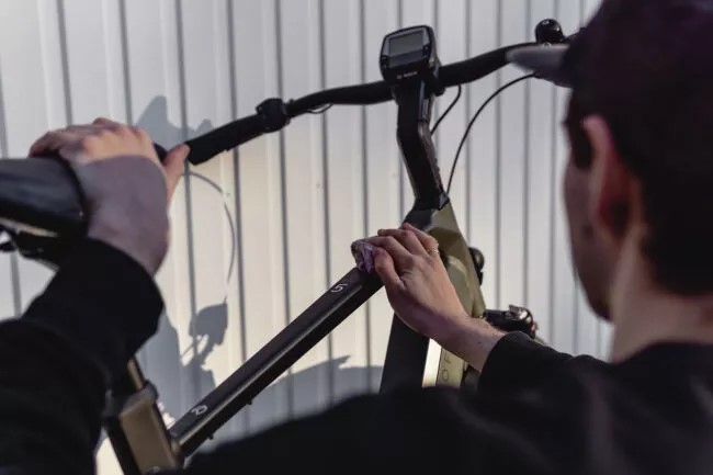 Mann wischt mit einem Lappen über seinen Rahmen