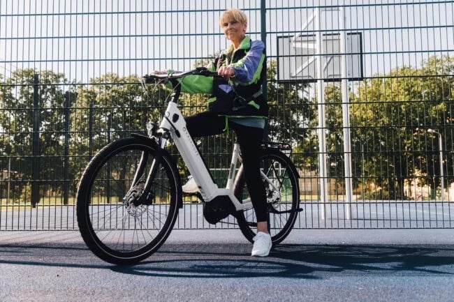 Frau sitzt auf ihrem Kalkhoff E-Bike mit Tiefeinsteiger Rahmen