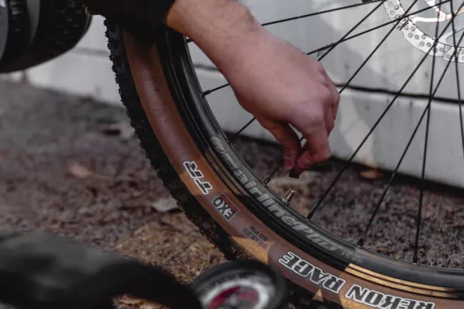 Mann pumpt den Reifen seines Kalkhoff E-Bikes auf