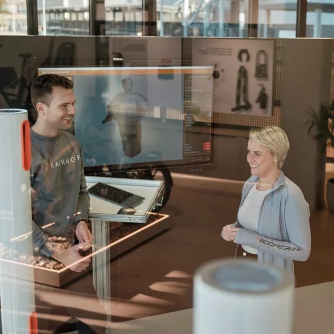 E-Bike fahren lernen: 5 Fahrtechnik-Tipps für Anfänger Mann berät gerade eine Frau beim Bodyscanning in der Brandworld