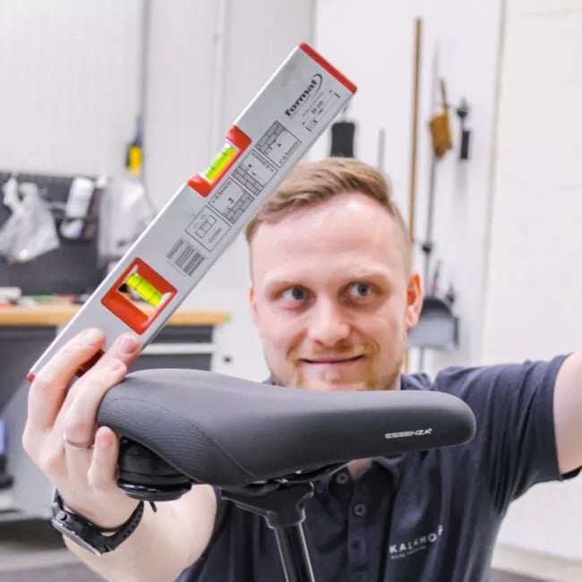 Hier wird eine Wasserwage an den Sitz rangehalten, um nach der richtigen Sitzposition zu gucken