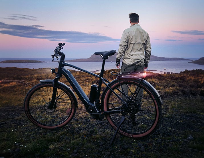 Mann steht vor seinem Kalkhoff E-Bike und blickt in die Ferne
